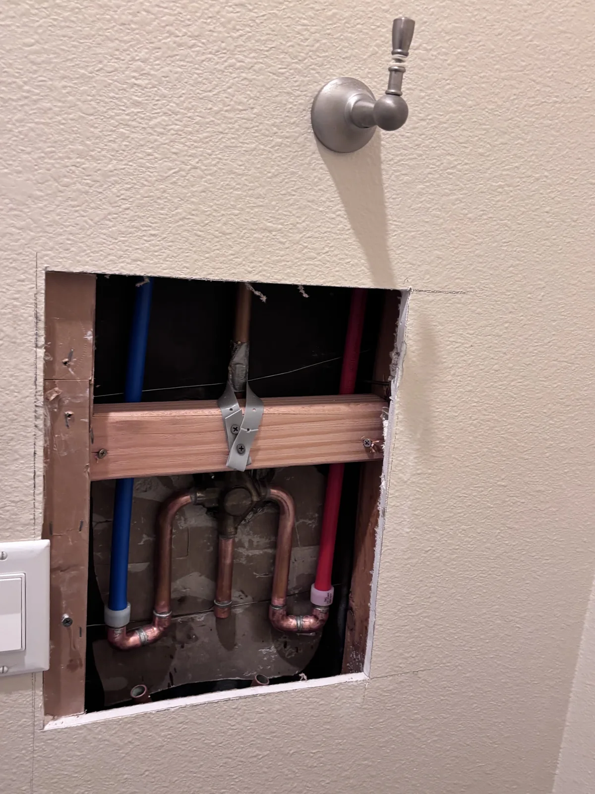 Red and blue water lines connected to the shower plumbing