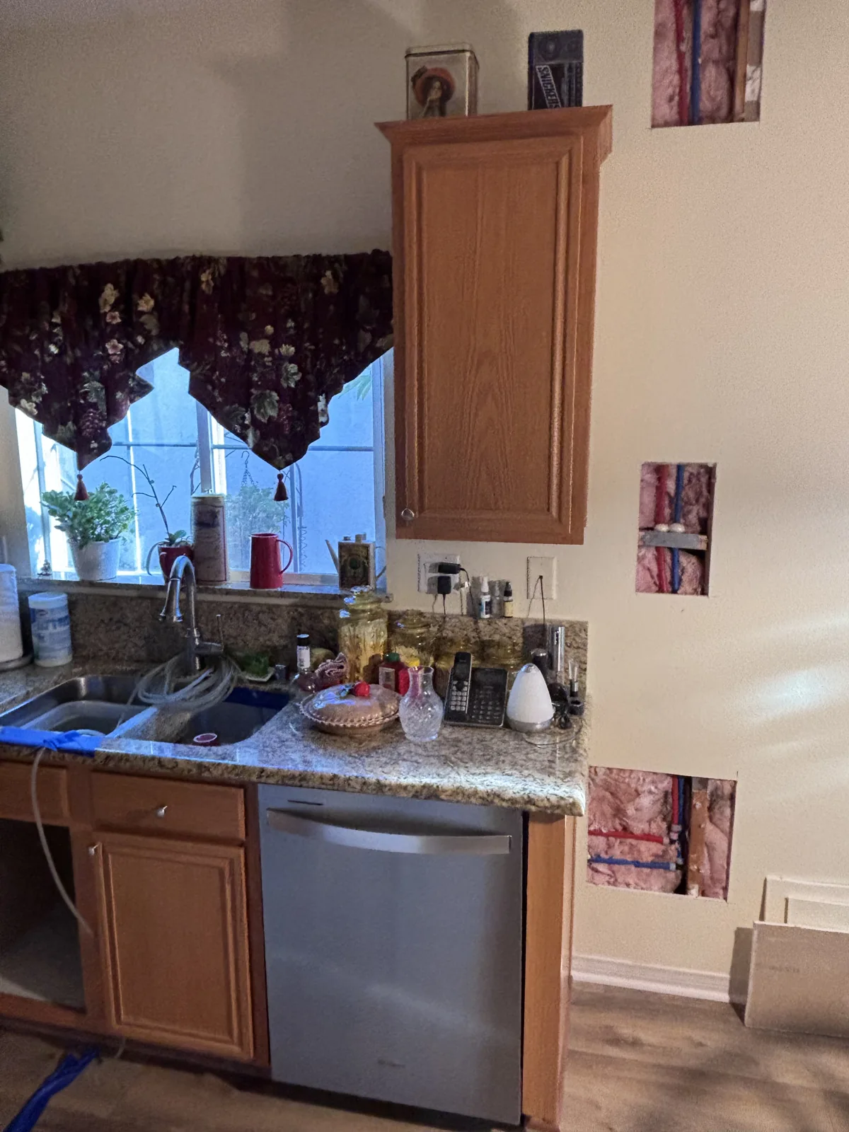 Hot and cold water lines visible through kitchen wall access openings