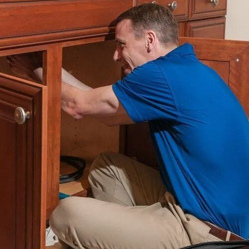 A plumber works on a reverse osmosis system.