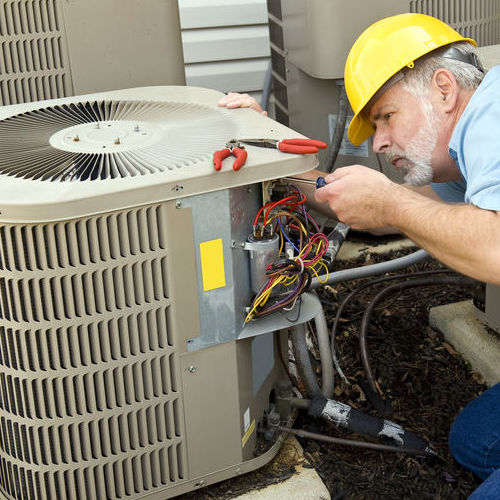 Technician repairs air conditioner.